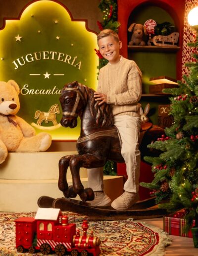 Madre e hijo junto al caballo de madera del decorado navideño