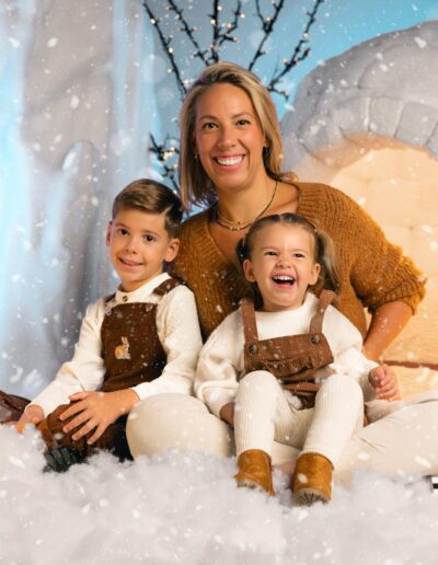 Madre y dos niñas durante una sesión navideña junto al iglú
