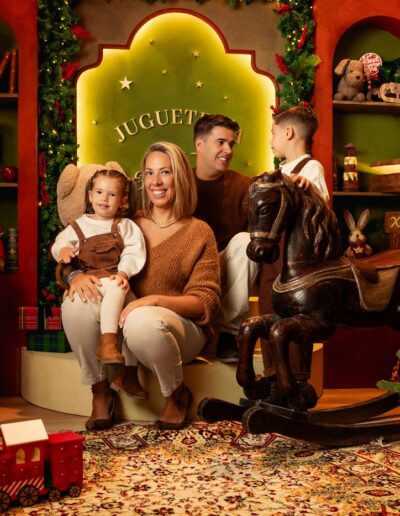Familia posando detrás del tren rojo del decorado Juguetería Encantada