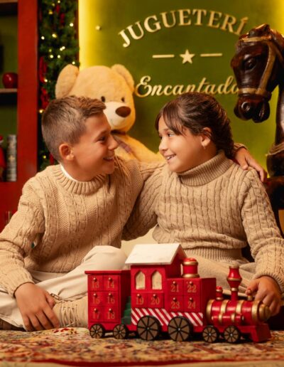Familia con niños sentada junto al tren del decorado navideño