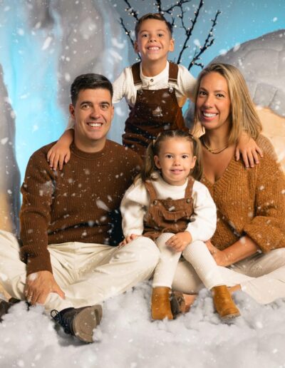 Familia numerosa posando en el decorado navideño del iglú