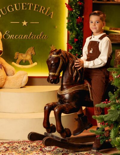 Niña posando entre juguetes en el decorado Juguetería Encantada