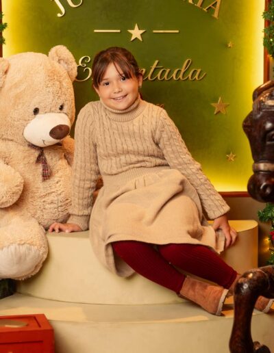 Niña sentada junto al oso de peluche en Juguetería Encantada